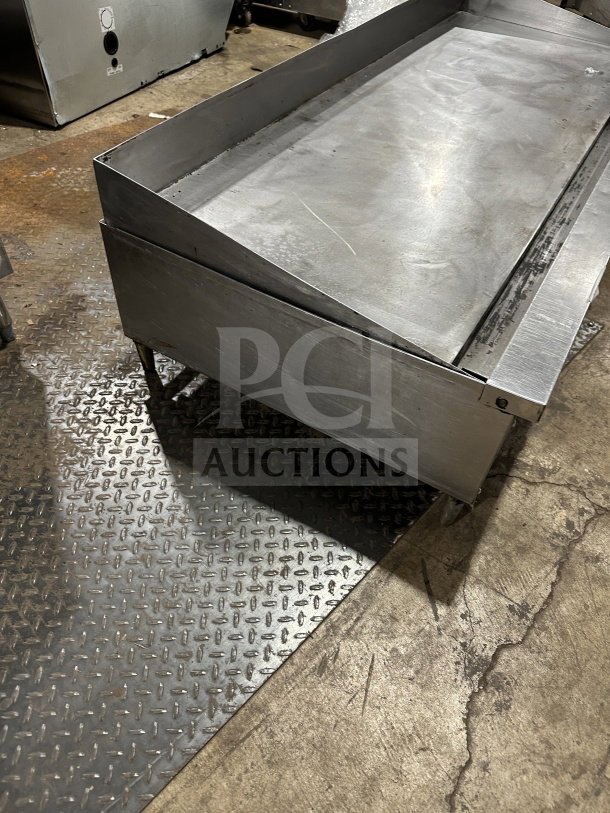 Garland Model 60.5 stainless steel gas griddle on legs, shows wear, suitable for commercial kitchens.