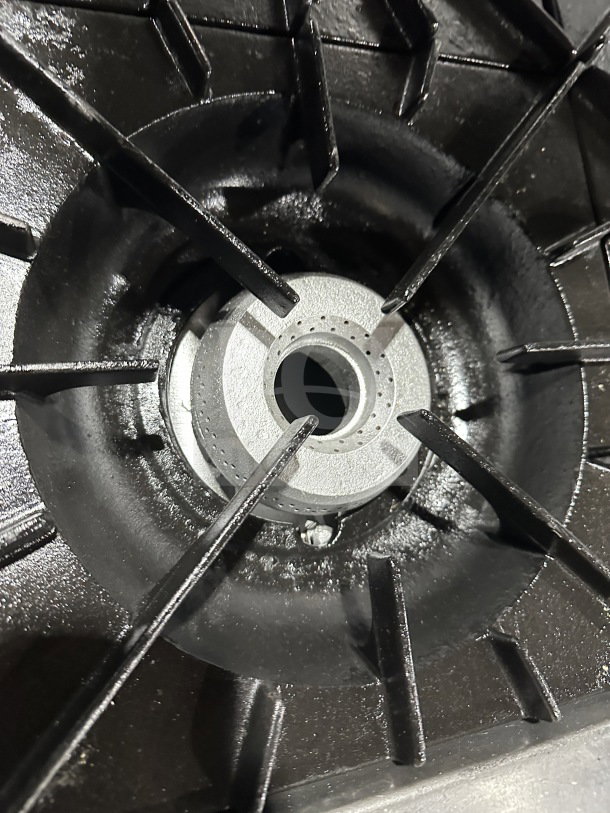 Close-up of a burner from a Vulcan 36L commercial stainless steel range; shows durable cast iron grates.