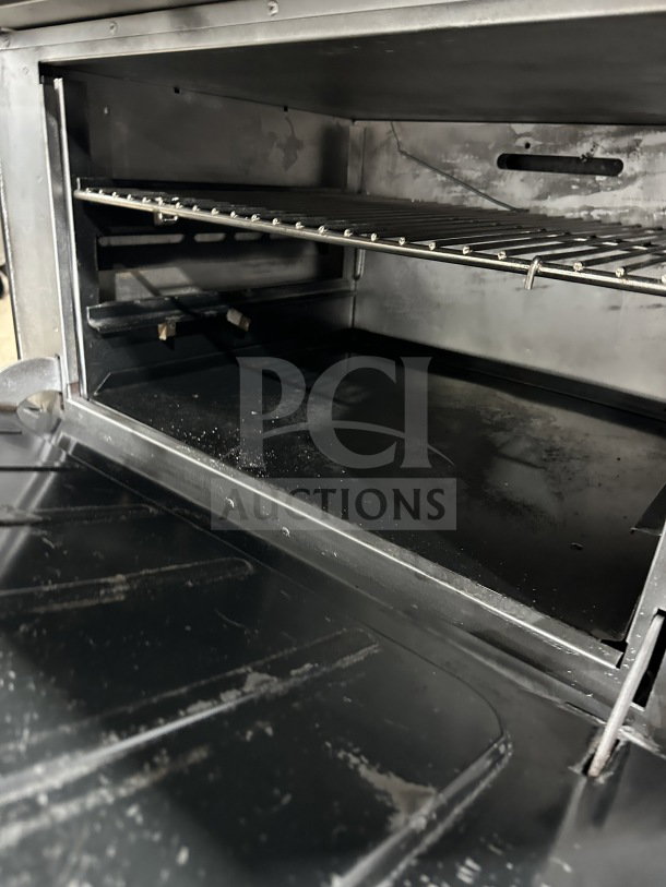 Vulcan 36L commercial stainless steel oven interior with rack. Features a French top, 6-burner range, on casters.