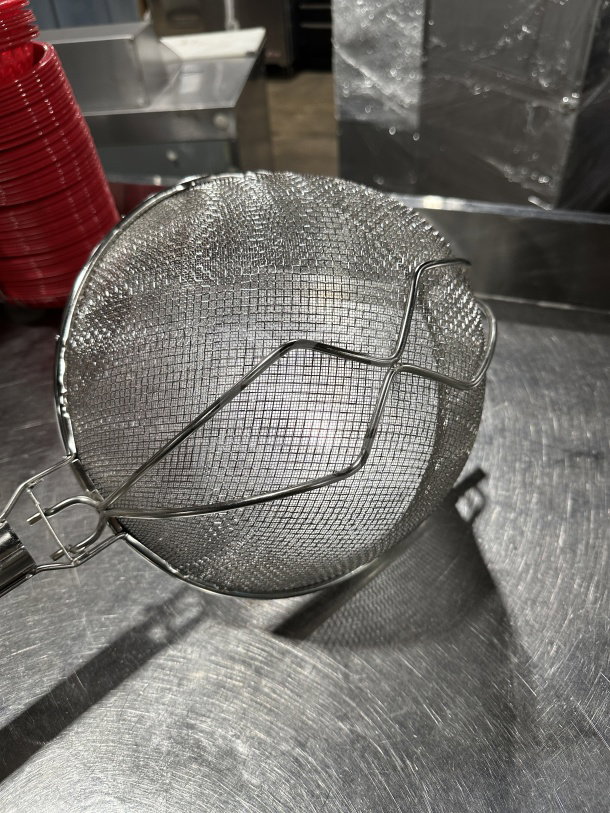 Brand new 12" double mesh stainless steel bowl strainer with handle, commercial-grade, on stainless steel surface.