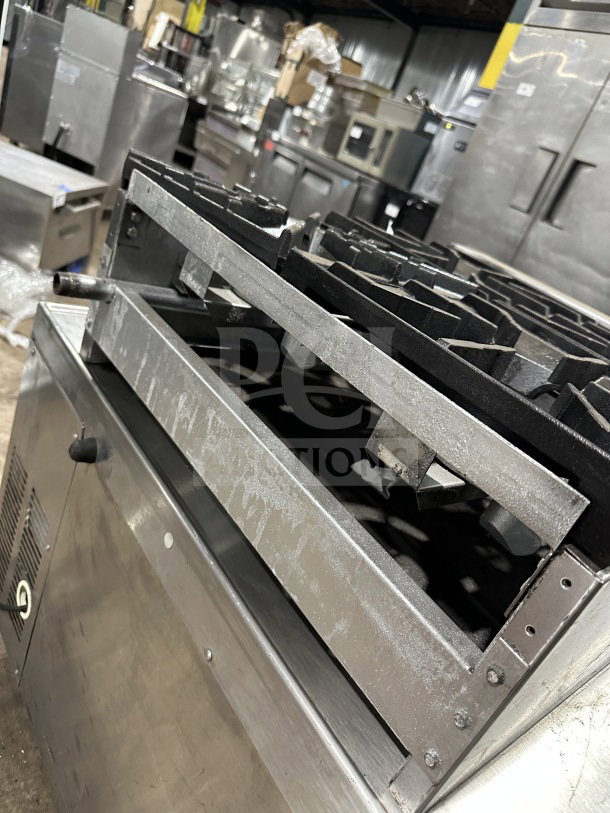 American Range stainless steel 4-burner hot plate in used condition, featuring thermostatic controls, suitable for commercial use.