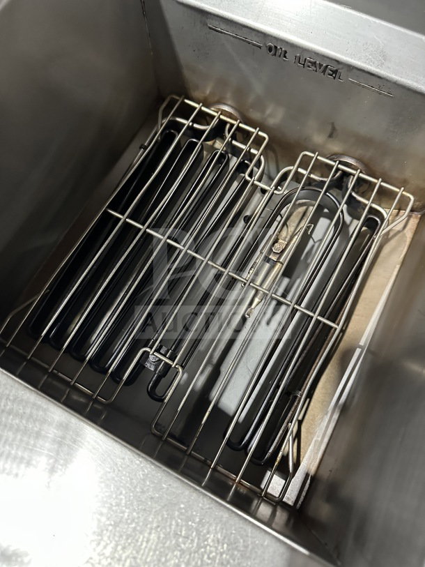 Imperial stainless steel electric deep fat fryer with basket hanger and back splash, on casters. Shows oil level marking.