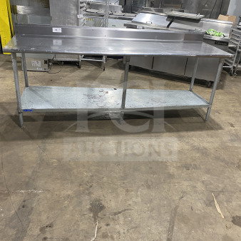 L&J stainless steel worktop table with undershelf, on legs. Durable commercial design, clean surface, ideal for kitchens.