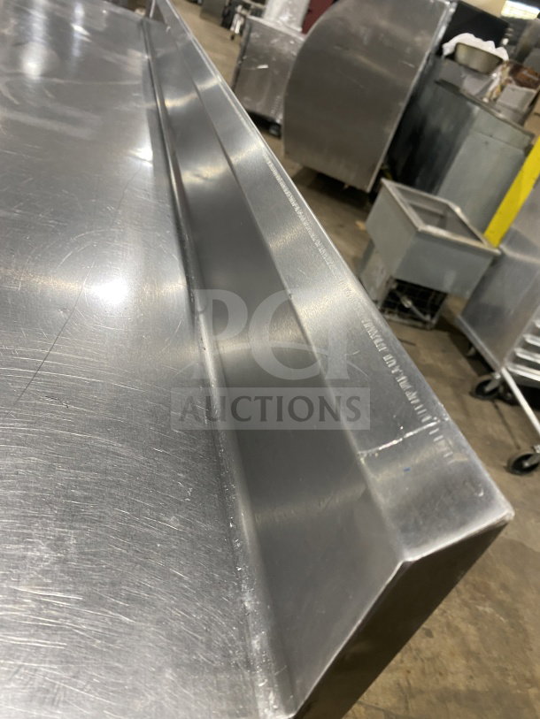 L&J stainless steel worktop table, single undershelf, on legs, commercial grade, visible light wear, durable finish.