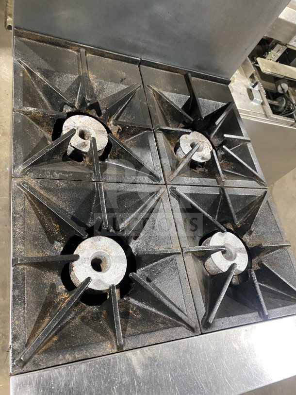 Southbend S241E stainless steel 4-burner gas range/oven with backsplash, overhead salamander shelf, and casters.