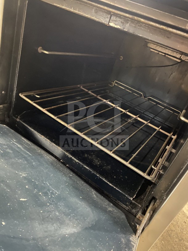 Southbend S241E stainless steel 4-burner range/oven with backsplash, salamander shelf, wired rack, and casters. Serial: 19H17274.
