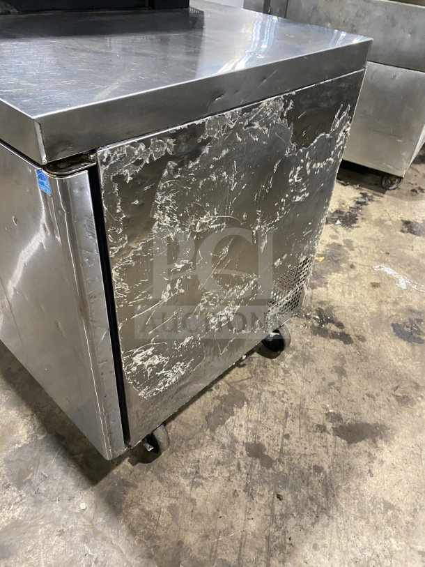 Migali stainless steel 2-door undercounter refrigerator, model C-U60R-HC, with poly coated wire rack, on casters. Shows wear.