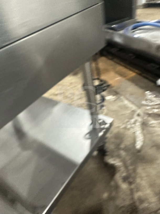 Commercial stainless steel griddle and cheese melter on casters, in good condition. Durable with visible storage shelf underneath.