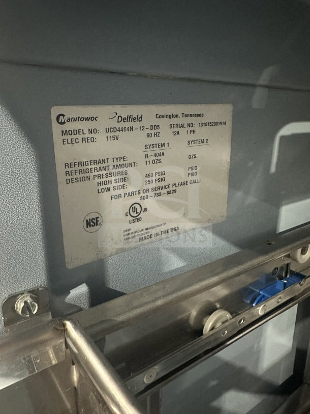 Label on Delfield Manitowoc stainless steel refrigerated prep table, model UCD4464N12DD5, details specs and serial number.