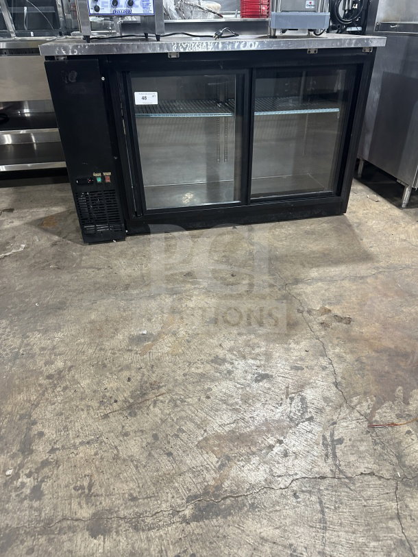 Commercial black back bar refrigerator with poly-coated wire rack, two sliding glass doors, and visible control panel.