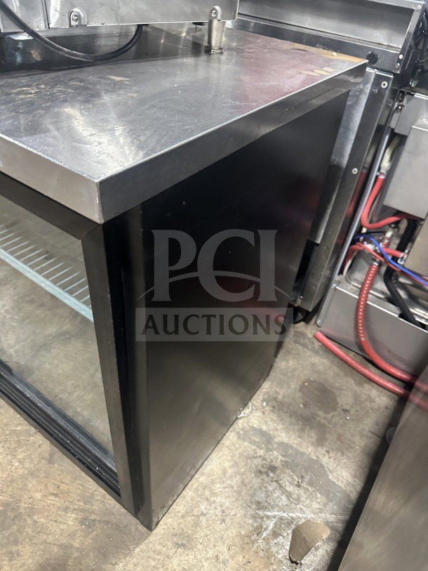 Commercial back bar black refrigerator with poly-coated wired rack and two sliding glass doors, excellent condition.