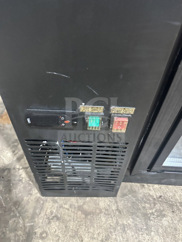 Commercial back bar black refrigerator with poly coated wired rack and two sliding glass doors, features light and power switches.