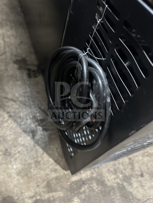 Black commercial back bar refrigerator with poly-coated wired rack, two sliding glass doors, and visible power cord.