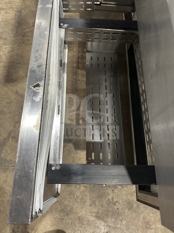 True stainless steel refrigerated sandwich prep table, model TSSU6016D2, with 4 drawers on casters. Visible wear.