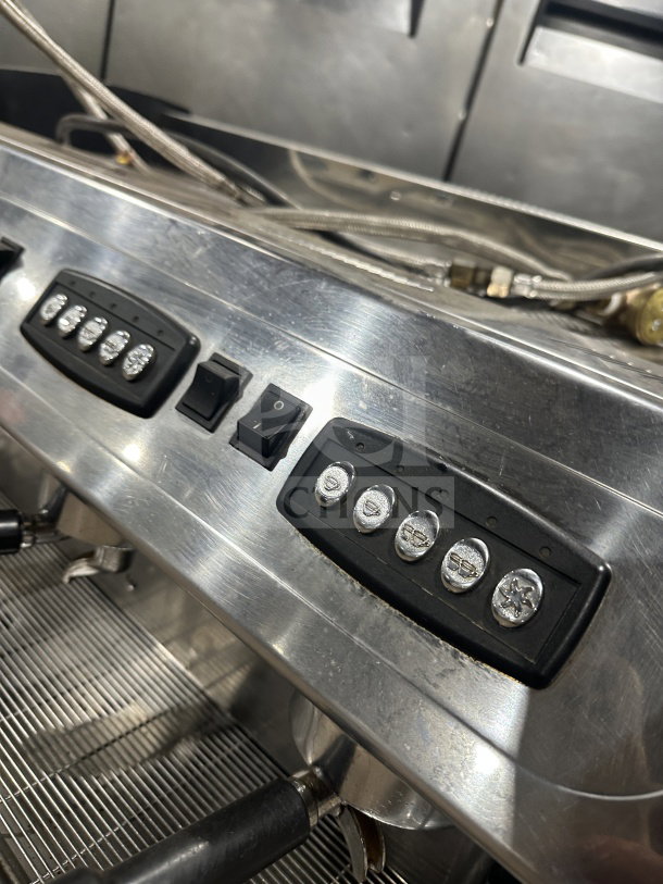 Danesi commercial stainless steel 3-group espresso machine, with multiple control buttons and porta filter handles.