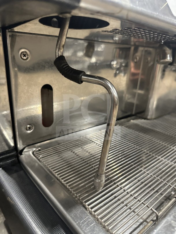 Danesi stainless steel 3-group commercial espresso machine with porta filter handles, shown on countertop.