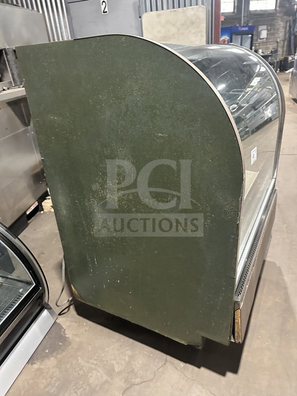 Stainless steel bakery display case with curved glass, 3 tiers, and rear sliding glass door. Features poly-coated rack.