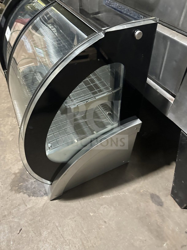 Vollrath RDE8363 commercial refrigerated display case with curved glass, stainless steel body, front and rear access doors.