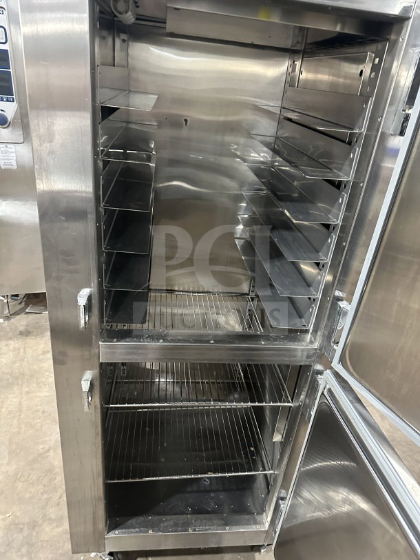 Traulsen RHT132WUT-HHS stainless steel reach-in refrigerator/freezer combo with pan slide, chrome rack, and casters.