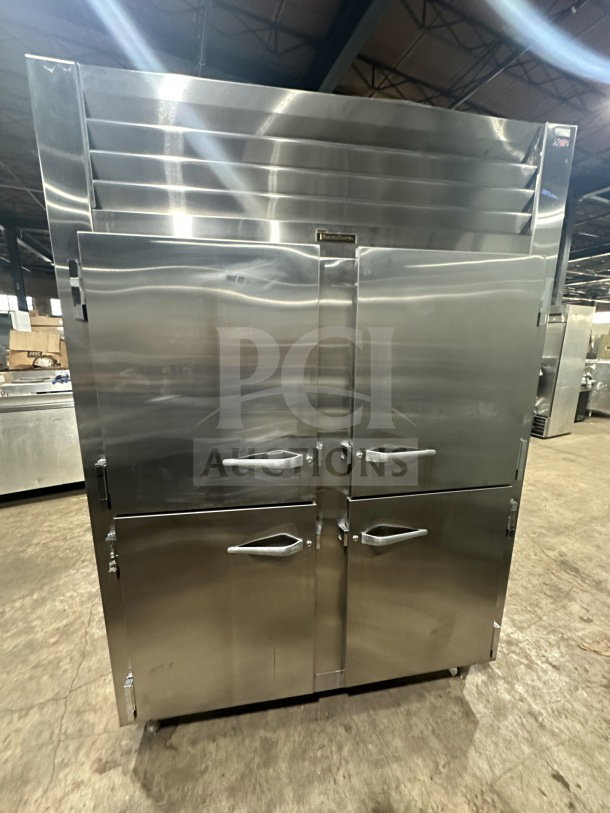 Traulsen stainless steel half-door double section reach-in refrigerator/freezer, model AHT232WUTHHS, with chrome racks, on legs.