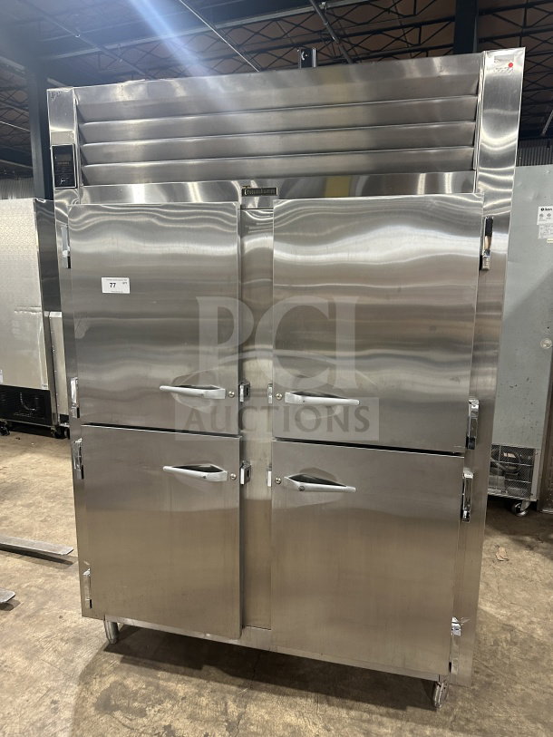 Traulsen AHT232WUT-HHS commercial stainless steel half-door refrigerator/freezer with chrome racks and pan slides, on legs.