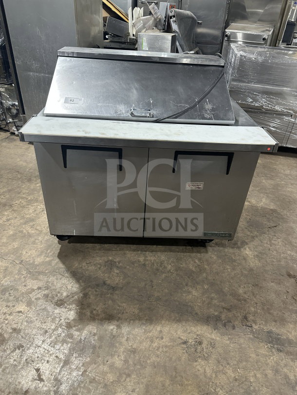 True commercial stainless steel 2-door refrigerated prep table with mega top, Model TSSU-48-18M-B-HC, on casters.