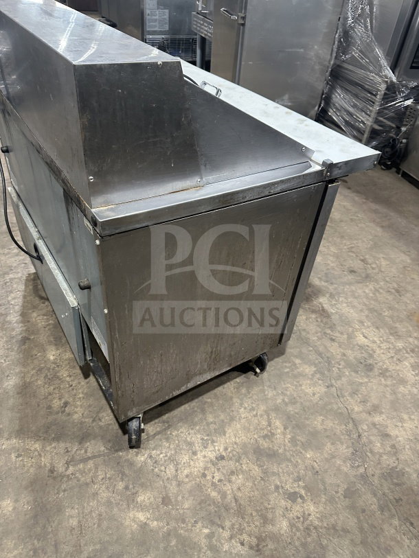 True commercial stainless steel 2-door refrigerated prep table, model TSSU-48-18M-B-HC, on casters, pre-owned.