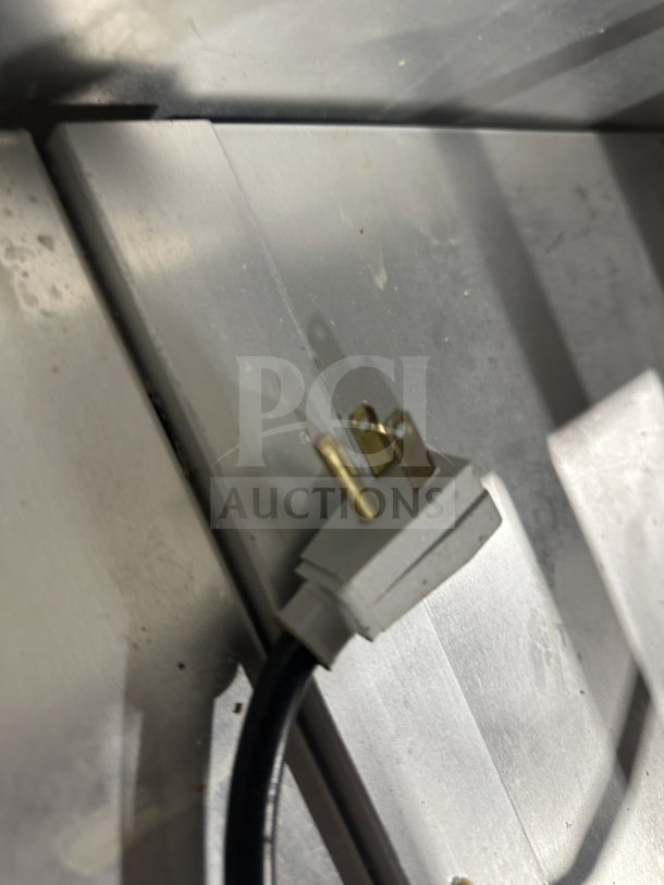 Close-up of a power plug on the True TSSU-48-18M-B-HC commercial prep table. Stainless steel surface visible.