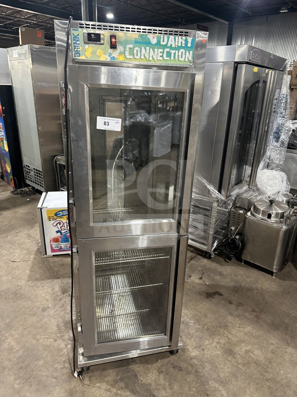 Randell PHHC26 glass half-door reach-in display refrigerator, chrome-plated rack, 115V, 1 phase, on casters, Dairy Connection signage.