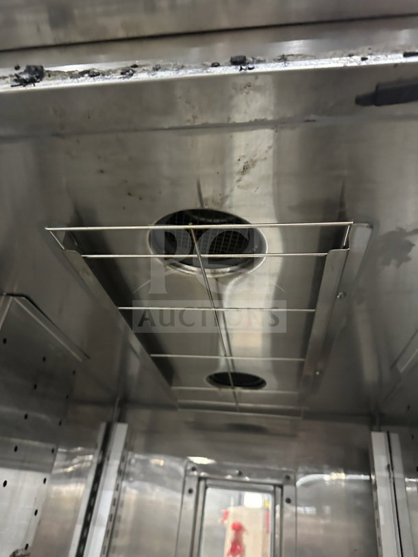Interior view of Randell PHHC-26 glass half-door reach-in refrigerator, featuring chrome-plated wire rack and age-related wear.