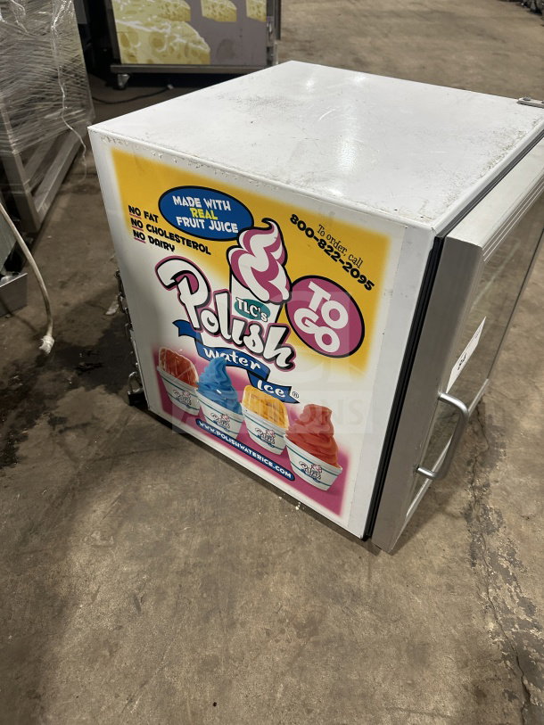 Commercial countertop single glass-door display cooler, poly-coated wire rack, colorful front graphic, on legs, fair condition.