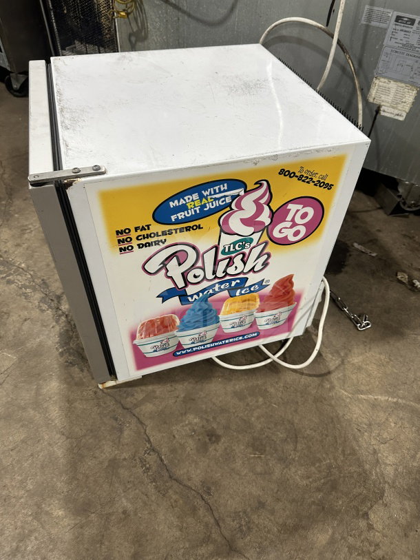 Commercial countertop single glass-door display cooler/freezer with poly coated wired rack, on legs, TLC's Polish Water Ice branding.