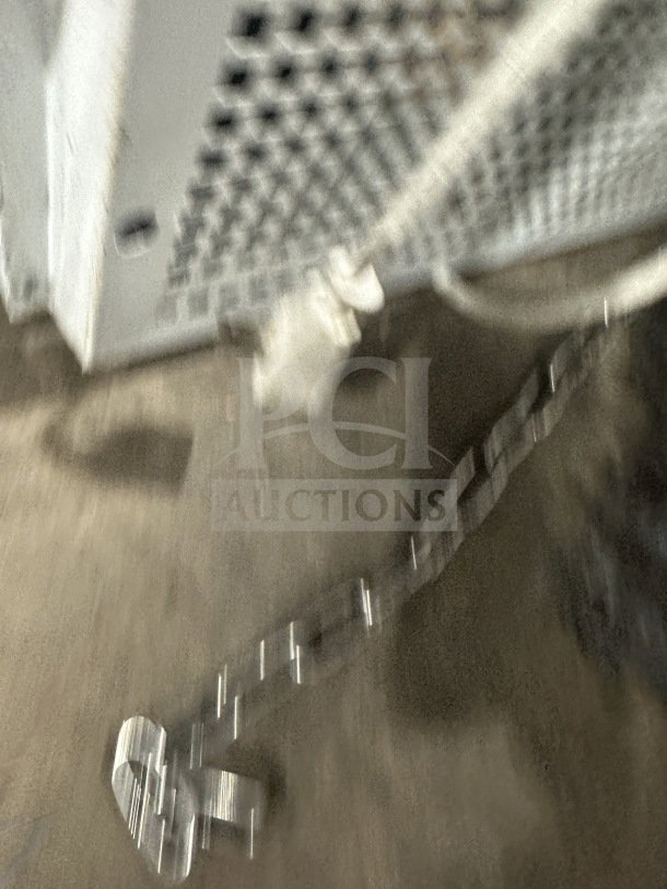 Blurred image of commercial countertop display cooler/freezer with poly coated wired rack, on legs. Details not clear.