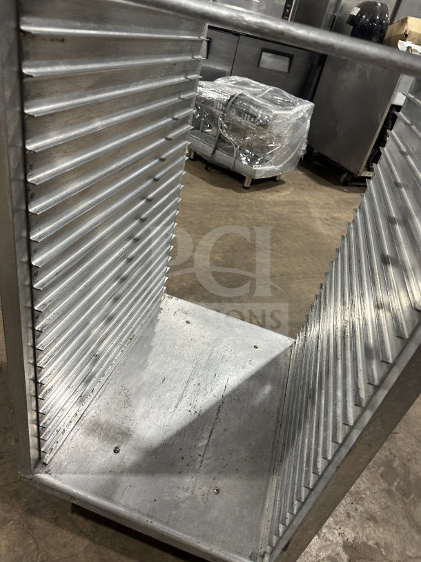Stainless steel heavy-duty sheet pan rack with casters, commercial-grade, multiple slots, good condition.