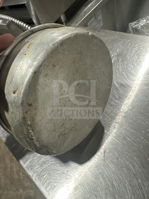 Stainless steel deep-dish pizza pan, commercial-grade, slightly worn condition, round shape, no visible markings.