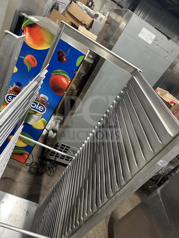Commercial stainless steel heavy-duty welded pan rack on casters, features multiple shelves, used condition.