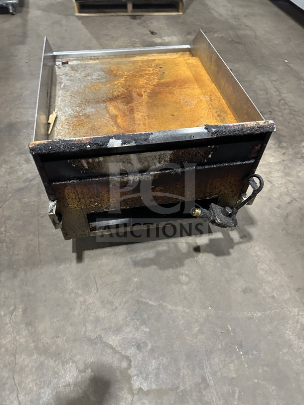 Southbend stainless steel countertop flat griddle, natural gas, with back and side splash, rusted surface, on legs.