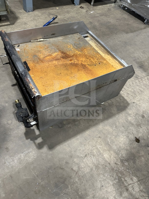 Southbend stainless steel natural gas-powered countertop griddle with back and side splash, visible rust, on legs.