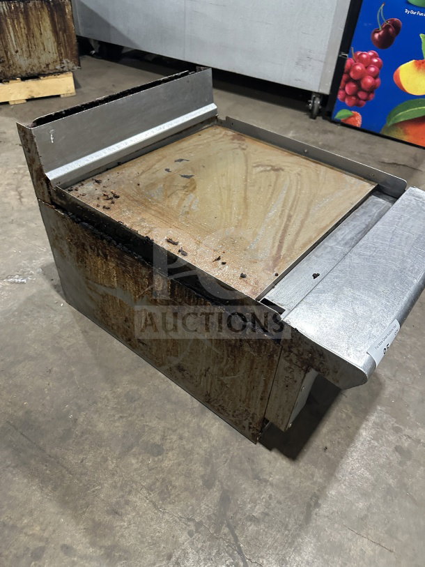 American Range stainless steel natural gas countertop griddle, featuring back and side splash, visibly used condition.