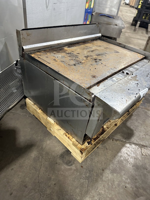 American Range stainless steel natural gas countertop griddle with back and side splash, visible wear and rust.