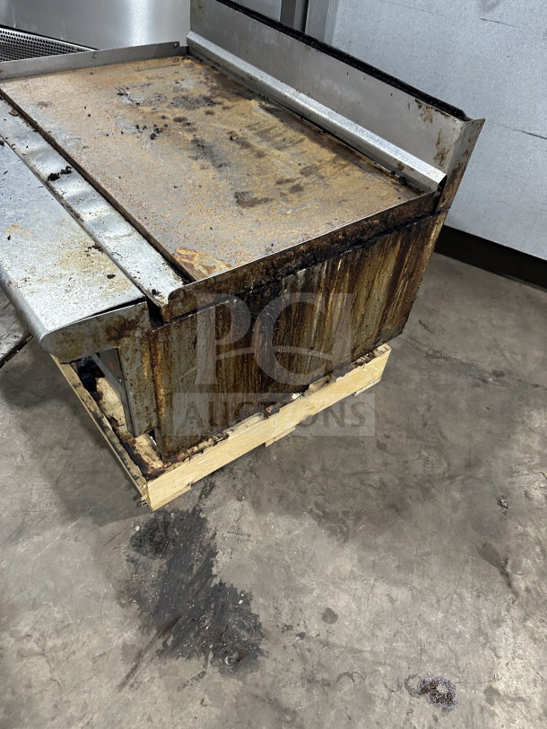 American Range commercial stainless steel gas griddle with back and side splash. Visible rust and wear indicate used condition.