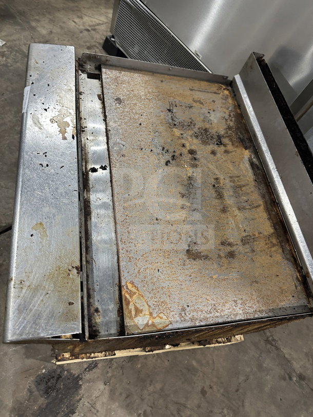 American Range stainless steel natural gas countertop griddle with back and side splash. Shows signs of heavy use.
