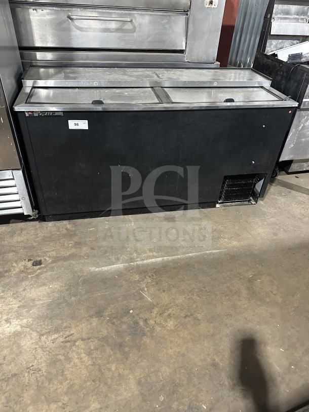 True commercial black horizontal forced air bottle cooler with stainless steel worktop and dual easy-slide lids. Good condition.