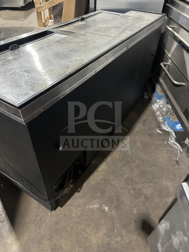 True commercial black horizontal forced air bottle cooler with stainless steel worktop and dual easy-slide access lid.