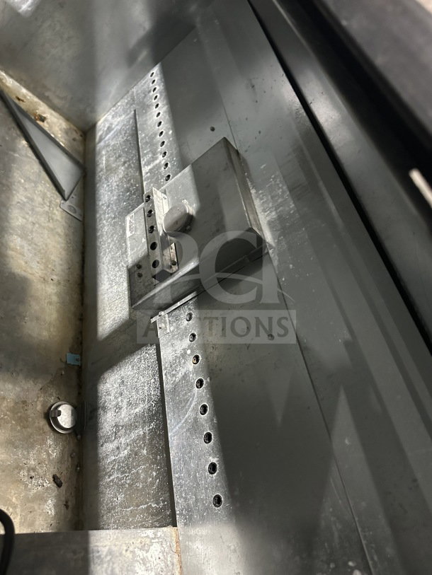 True commercial black horizontal forced air bottle cooler interior showing steel components. Steel worktop, dual easy-slide access lid not visible.