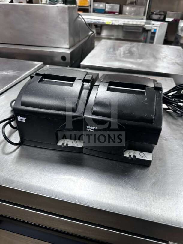 Star Micronics SP700/SP742 impact receipt printers, quantity 2, fully tested, 100–240V, in prime condition, shown on a metal surface.