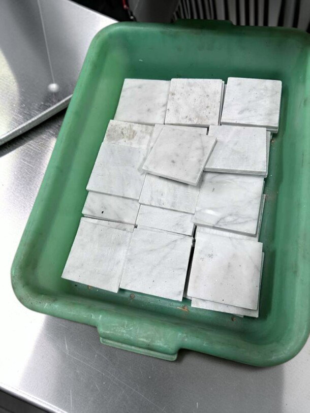 Carrara White Marble 4x4 honed tiles in outstanding condition, arranged in a green container, suitable for walls and backsplashes.