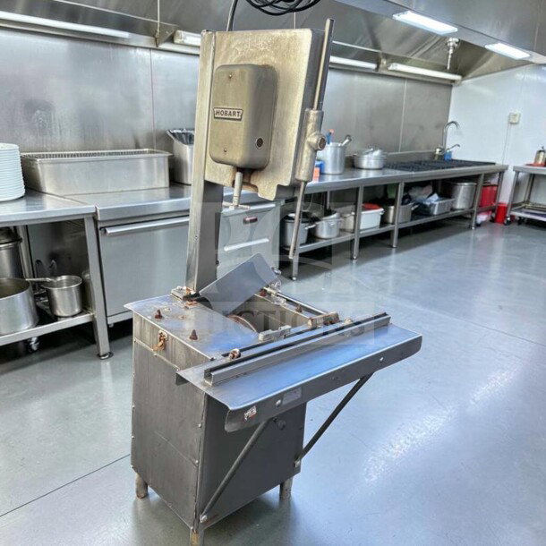 Hobart 5614 commercial meat saw in kitchen setting, 2 HP, 3 phase, metal construction, for parts or repair.