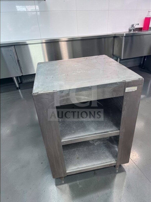 Commercial stainless steel equipment stand in excellent condition, featuring two open shelves for storage, model COM-S-STD-0687.