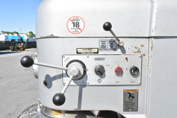 Hobart M802 dough mixer control panel, showing levers and warning labels. Features include clutch and speed dial.